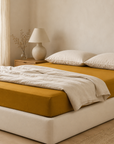 Fronhas Charming ocre em flanela chambray 100% algodão sobre cama com roupa branca, num quarto luminoso e sereno - BellaGoma