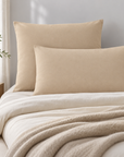 Fronhas Charming em Areia numa cama em tons claros, num quarto sereno