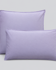 Almofadas com fronhas Stone lavanda sobre fundo cinzento.