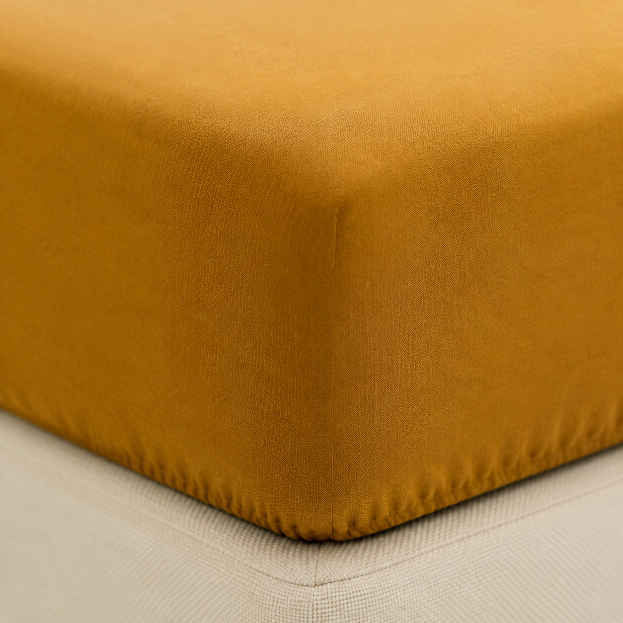 Pormenor de duas Fronhas Charming ocre sobre roupa de cama branca, revelando a textura suave da flanela chambray - BellaGoma