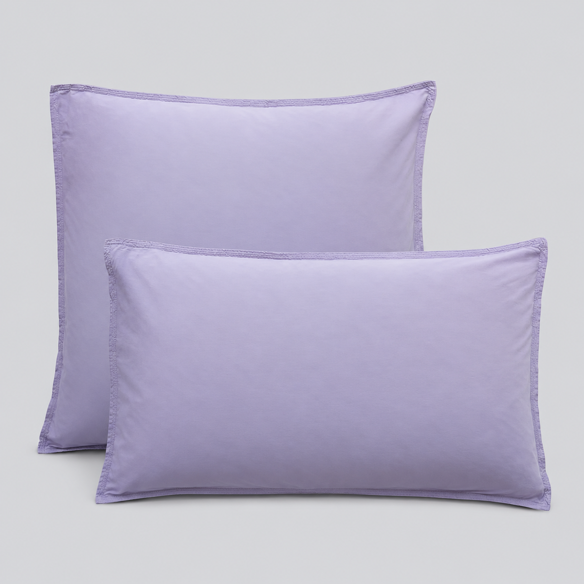 Almofadas com fronhas Stone lavanda sobre fundo cinzento.
