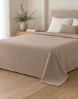 Colcha BellaClove bege sobre cama num quarto em tons neutros