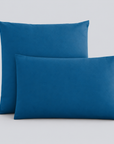 Fronhas Charming em Azul/Petróleo sobrepostas sobre fundo cinzento