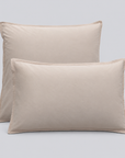 Duas almofadas com fronhas Stone bege em percale 100% algodão sobre fundo cinzento-claro.