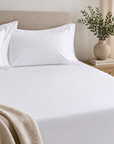 Lençol Ajustável BellaLux branco ajustado ao colchão numa cama elegante