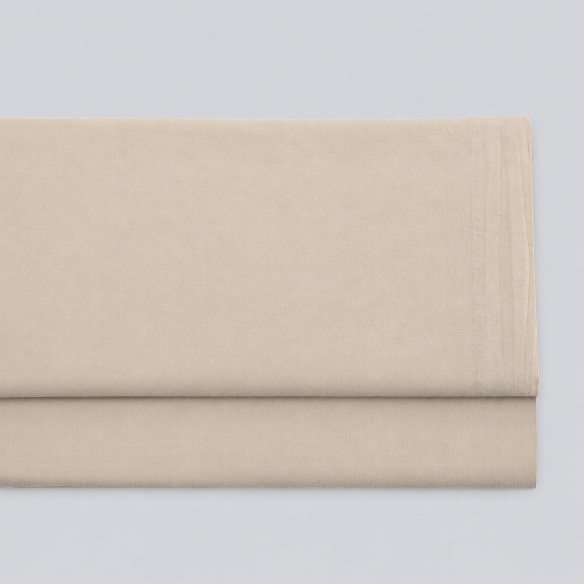 Lençol de cima Stone bege em percale 100% algodão, dobrado com a bainha superior visível.