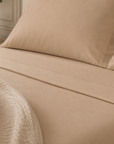 Linha Charming BellaGoma em bege - lençóis e fronhas em cama.