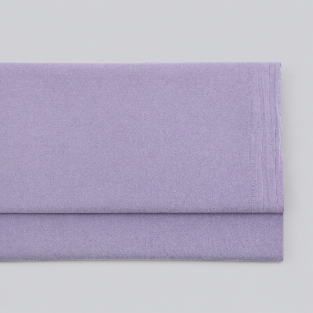 Lençol de cima Stone lavanda em percale 100% algodão, dobrado com a bainha superior visível.